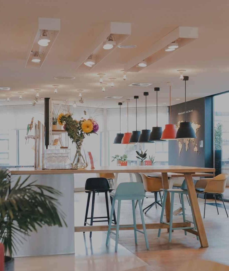 A warm, architectural co-working lounge with communal seating and pendant lighting